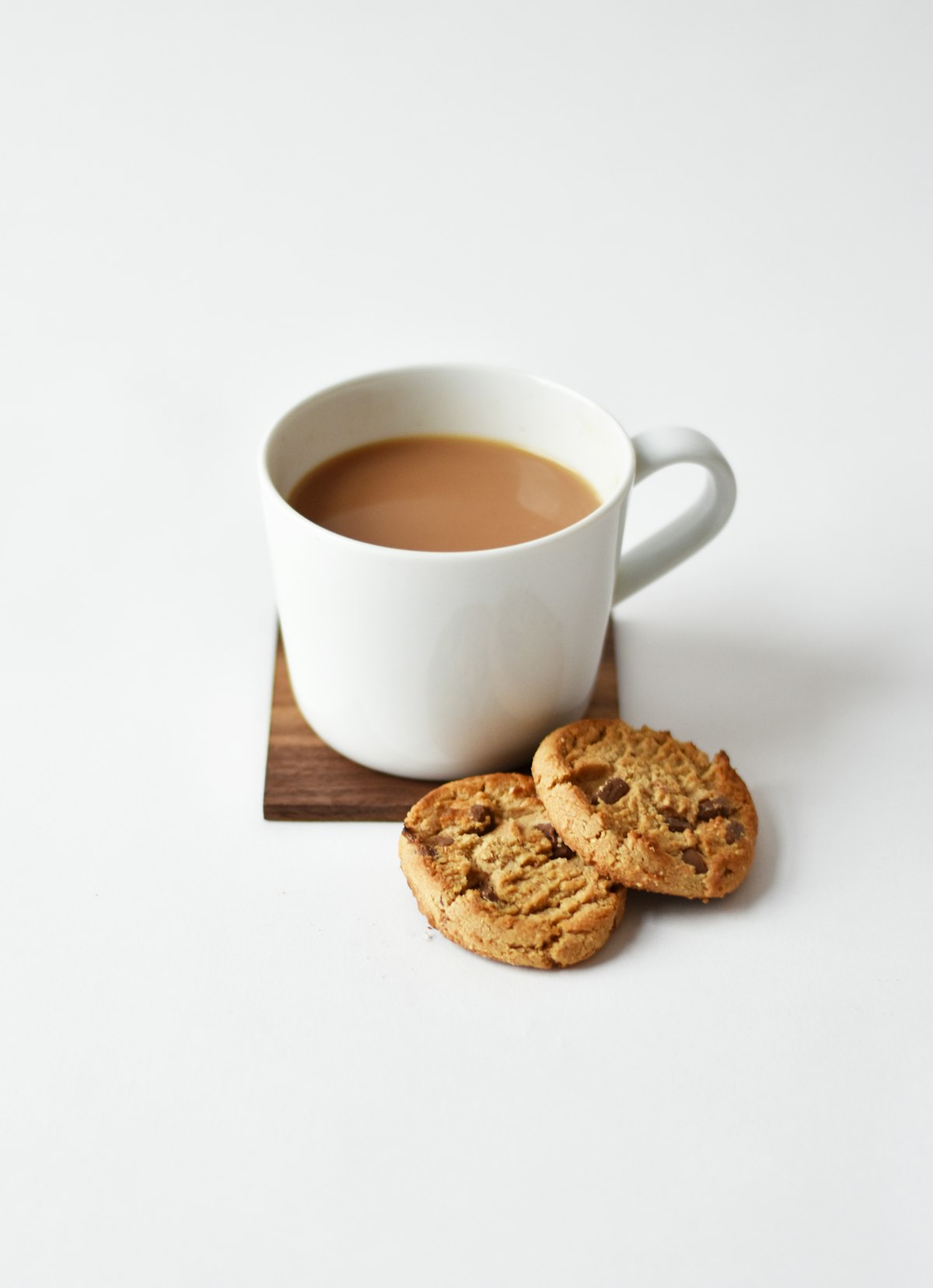 Steaming mug of herbal chamomile tea on a wooden table beside a book